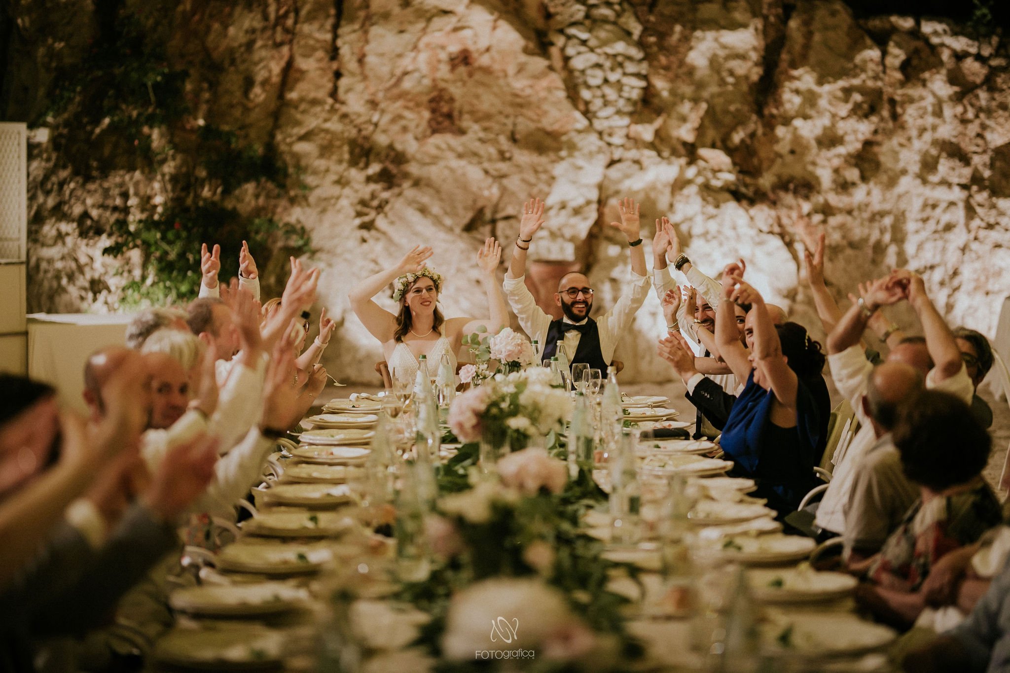Matrimonio intimo a Cala dei Balcani — sposi e ospiti felici alla tavola nella grotta, Cozy Wedding Salento, Puglia