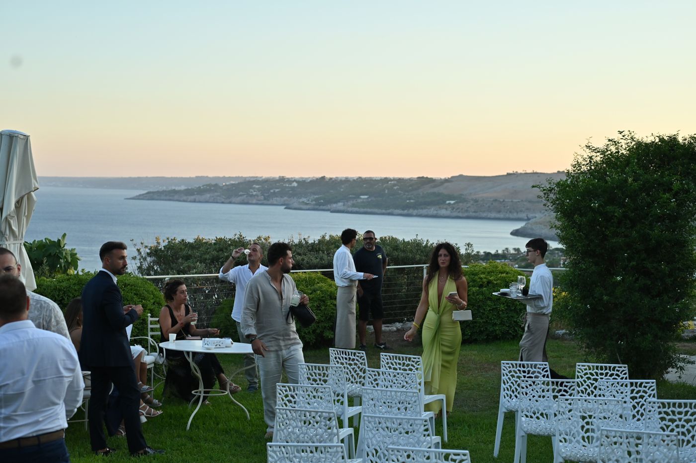 Guests on the terrace looking out to sea at sunset